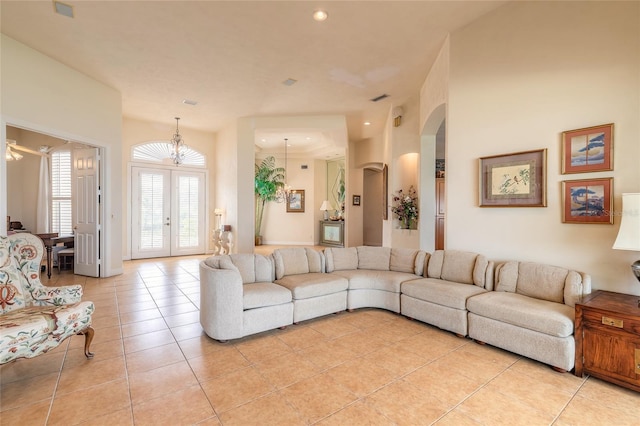 living room featuring light tile patterned floors, arched walkways, recessed lighting, visible vents, and french doors