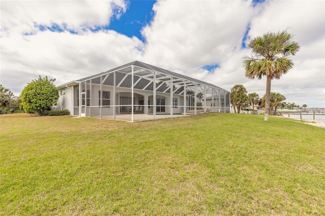 back of property with glass enclosure and a lawn