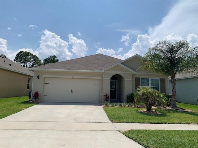 ranch-style house with a front yard, concrete driveway, and stucco siding