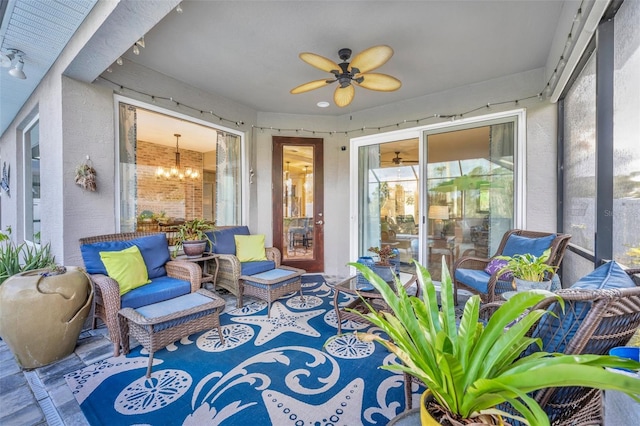 sunroom featuring ceiling fan with notable chandelier