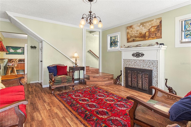 living area with a textured ceiling, a fireplace, dark wood-style flooring, and crown molding