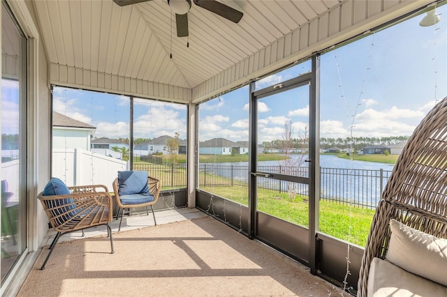 sunroom featuring a water view, lofted ceiling, and ceiling fan