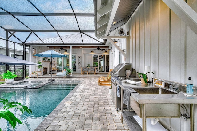 view of swimming pool featuring a patio, area for grilling, a ceiling fan, outdoor wet bar, and a lanai