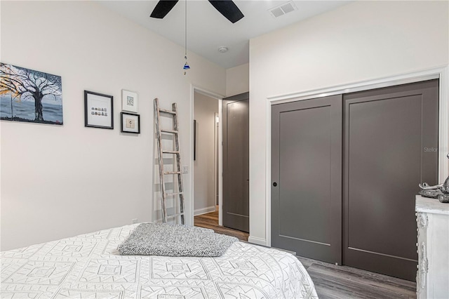 bedroom featuring a closet, visible vents, ceiling fan, and wood finished floors