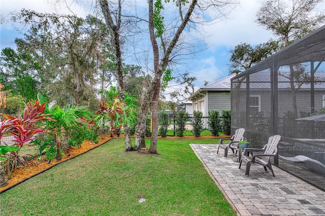 view of yard with a lanai, a patio area, and fence