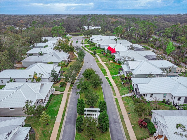 drone / aerial view featuring a residential view and a wooded view