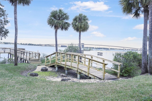 dock area with a water view and a lawn