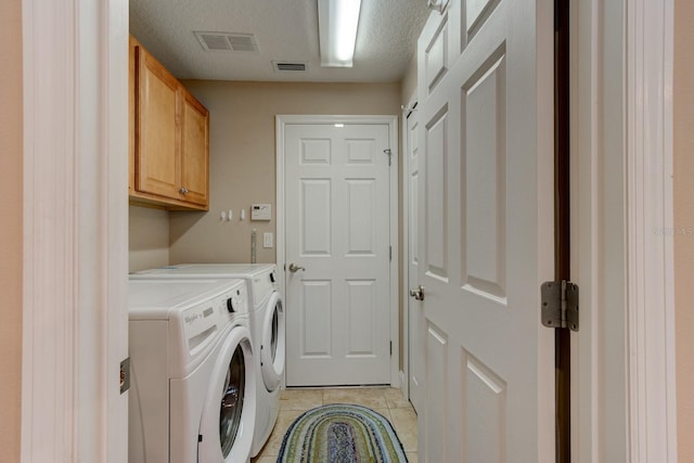 laundry area featuring cabinet space, light tile patterned floors, visible vents, and washer and dryer