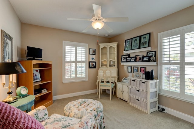 sitting room with ceiling fan, baseboards, and light colored carpet