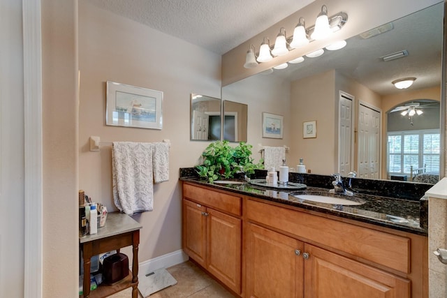 bathroom with visible vents, baseboards, tile patterned flooring, a textured ceiling, and vanity