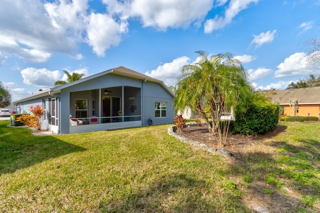 back of house featuring a sunroom and a lawn