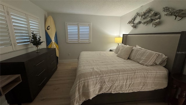 325 N Causeway Unit B101, New Smyrna Beach, FL 32169 - bedroom with wood finished floors and a textured ceiling