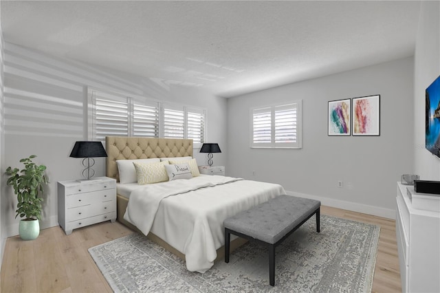 325 N Causeway Unit B101, New Smyrna Beach, FL 32169 - bedroom with light wood finished floors and a textured ceiling