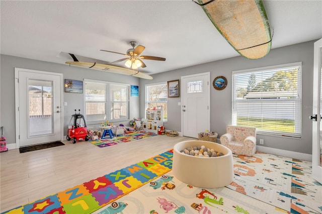 playroom featuring ceiling fan, wood finished floors, and baseboards