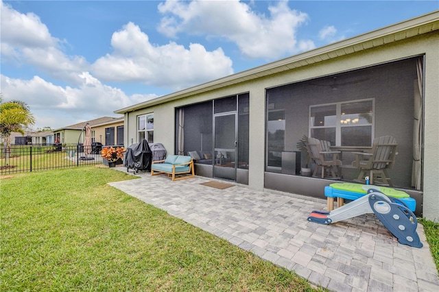 back of property with a lawn, a patio area, fence, and a sunroom