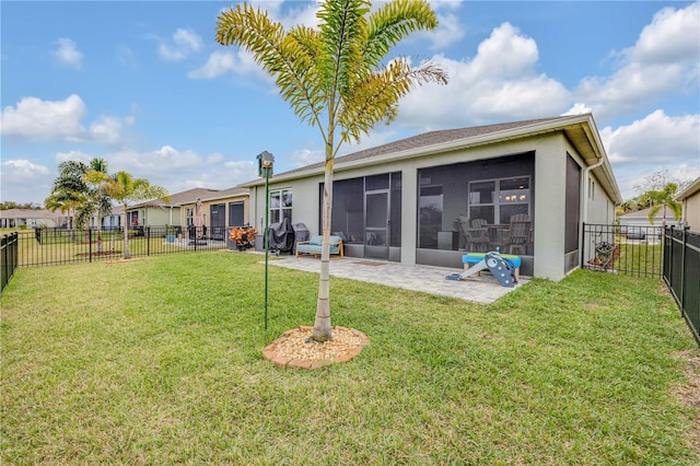 rear view of property featuring a fenced backyard, a sunroom, a lawn, stucco siding, and a patio area