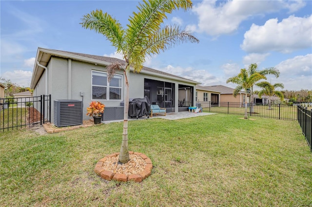 back of property with a sunroom, central AC unit, and a lawn