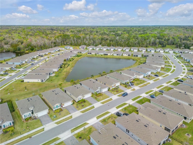 aerial view featuring a forest view, a water view, and a residential view