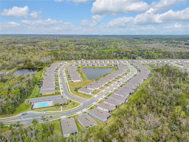 birds eye view of property featuring a water view and a wooded view