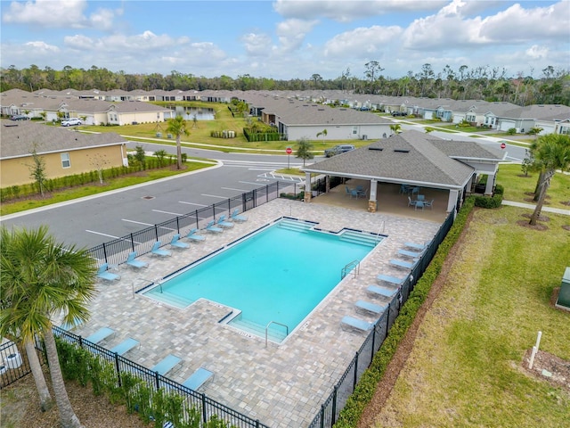 pool with a residential view, fence, and a patio