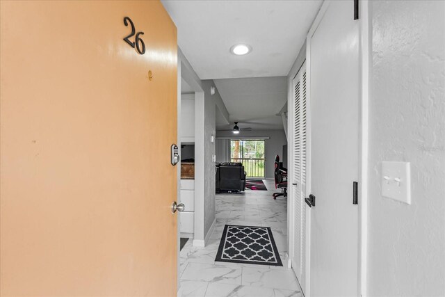 hall with marble finish floor and baseboards