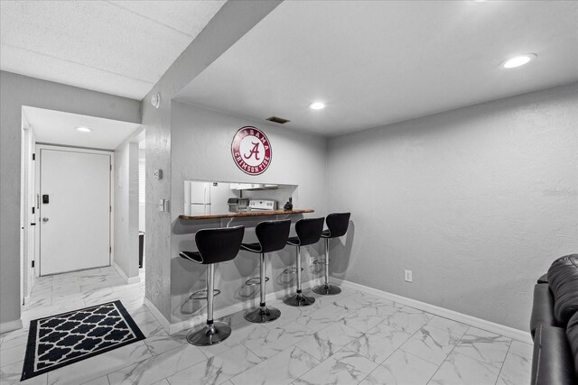 bar with visible vents, baseboards, indoor bar, marble finish floor, and recessed lighting