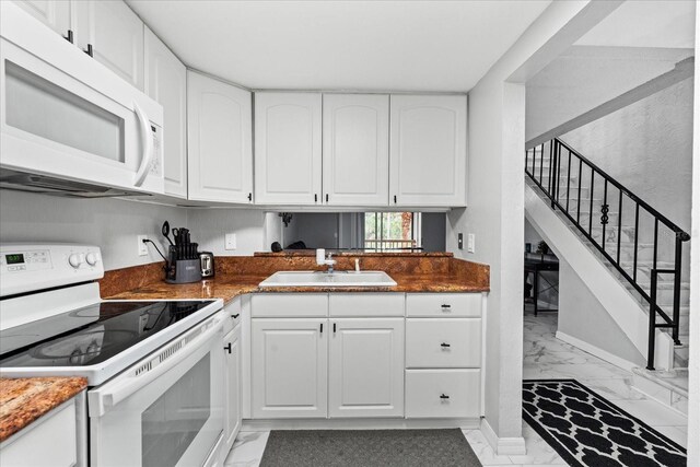 kitchen featuring marble finish floor, white appliances, a sink, and white cabinetry