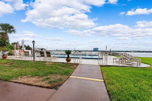 exterior space with a water view and a lawn