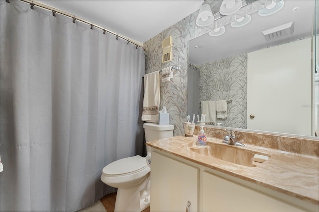 full bathroom with visible vents, vanity, toilet, and wallpapered walls