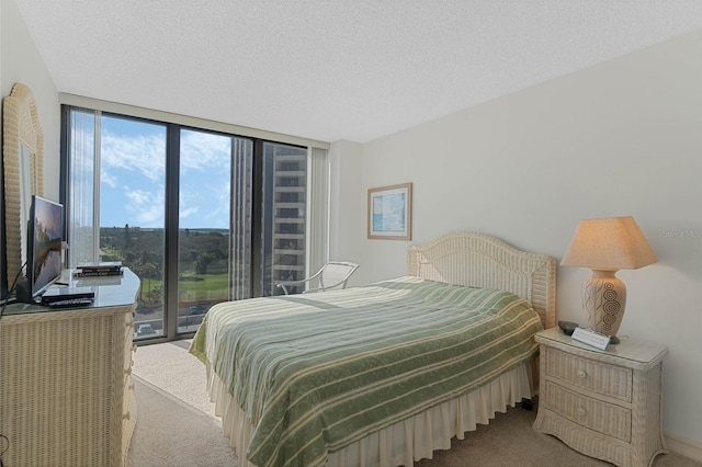 bedroom featuring access to outside, a textured ceiling, floor to ceiling windows, and carpet flooring