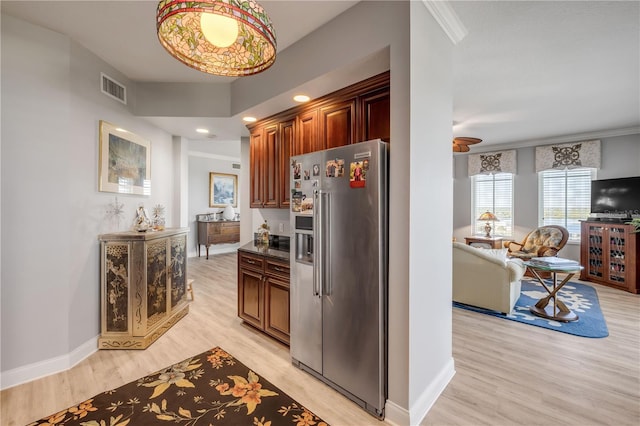 kitchen with dark countertops, visible vents, high quality fridge, light wood-type flooring, and baseboards