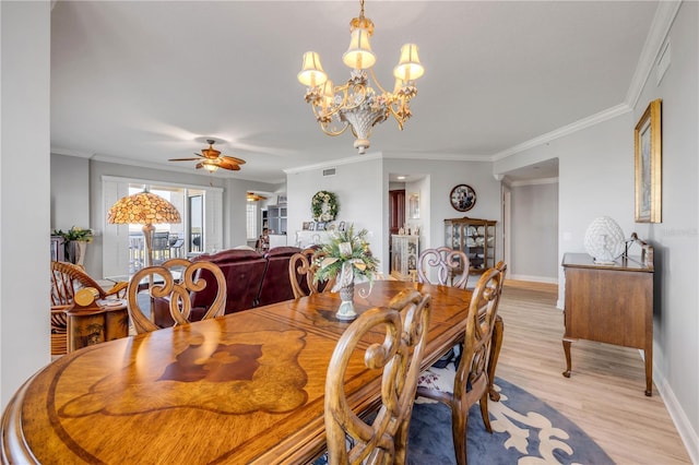 dining area with visible vents, baseboards, crown molding, light wood-style floors, and ceiling fan with notable chandelier