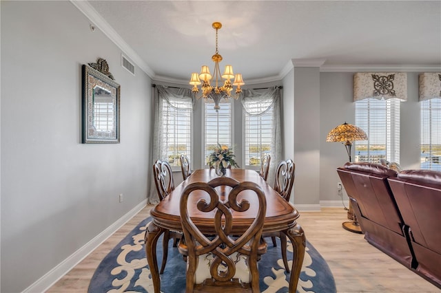 dining area featuring a wealth of natural light, light wood-type flooring, visible vents, and an inviting chandelier