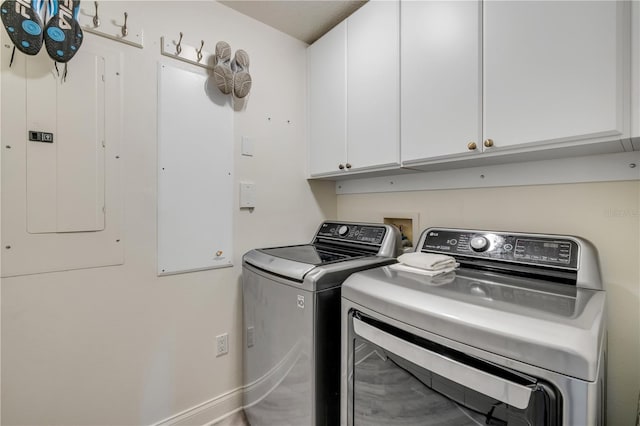 washroom featuring washing machine and dryer, electric panel, and cabinet space