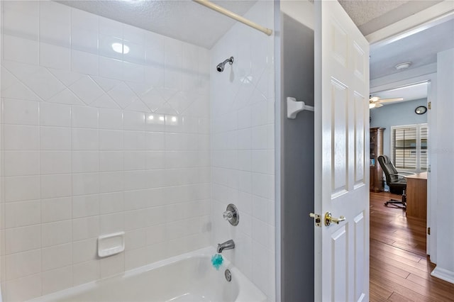 full bath featuring a textured ceiling, ceiling fan, bathtub / shower combination, connected bathroom, and wood finished floors