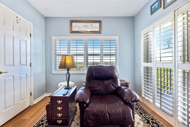 living area with baseboards and wood finished floors