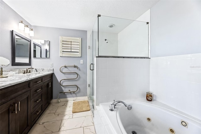 full bath with a textured ceiling, marble finish floor, a shower stall, double vanity, and a tub with jets