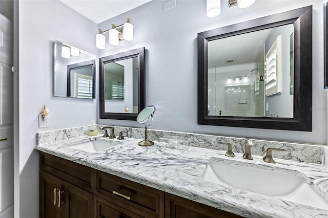 full bathroom with a stall shower, a sink, and double vanity