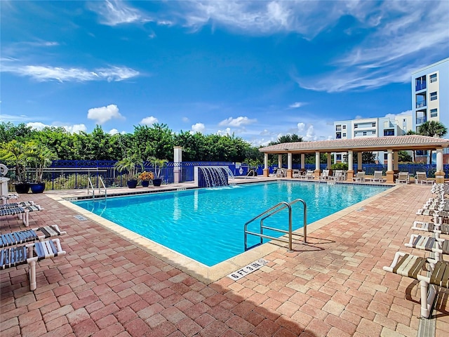 community pool with fence and a patio