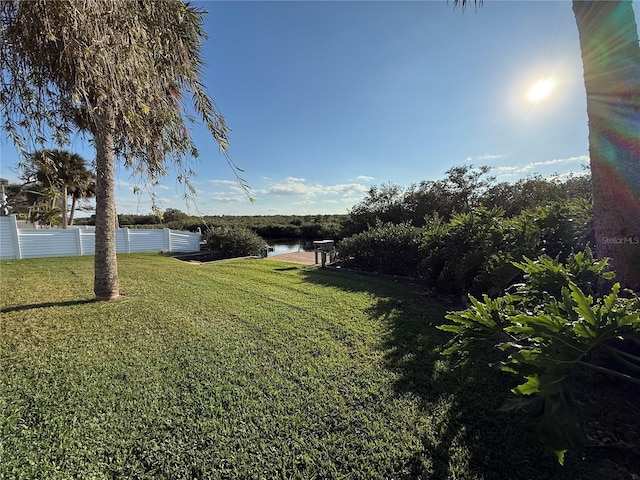 view of yard with a water view and fence