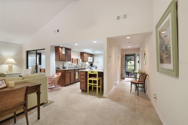 kitchen with open floor plan, light countertops, visible vents, and a kitchen breakfast bar