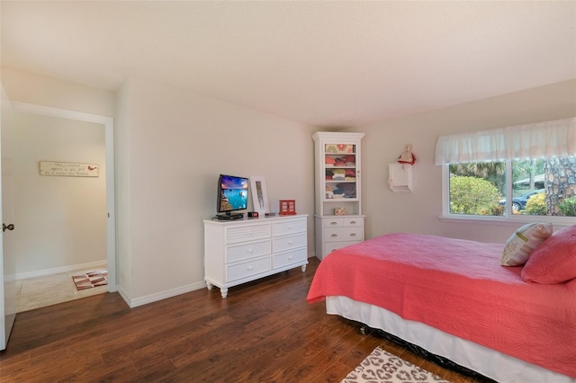 bedroom with baseboards and wood finished floors