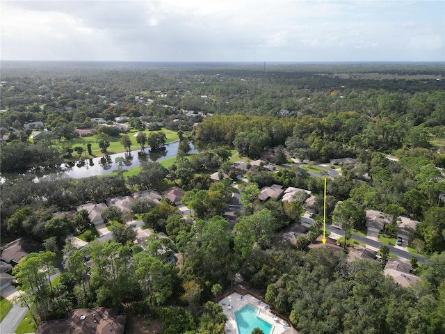 birds eye view of property featuring a water view and a view of trees