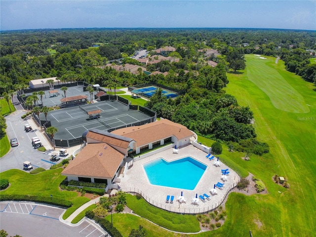 birds eye view of property with view of golf course and a forest view