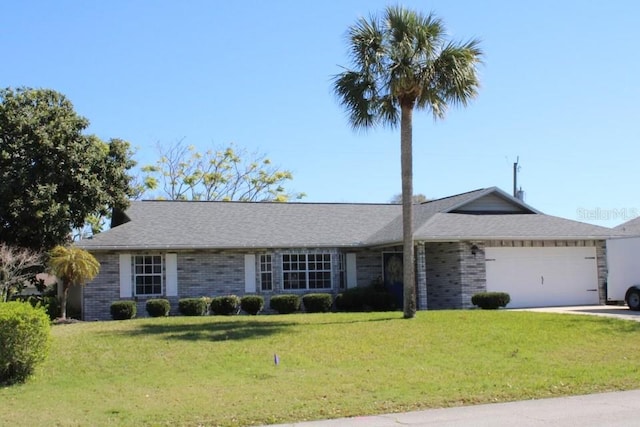 single story home featuring a garage, a front yard, concrete driveway, and brick siding