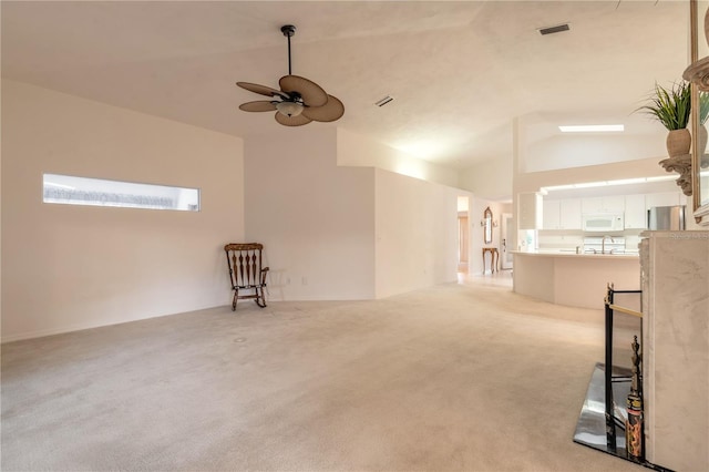 unfurnished room with ceiling fan, high vaulted ceiling, light colored carpet, a sink, and visible vents