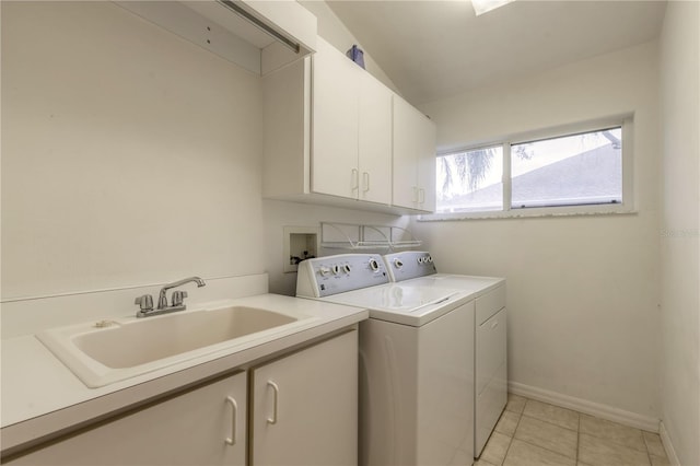 laundry area featuring light tile patterned floors, washing machine and dryer, a sink, baseboards, and cabinet space