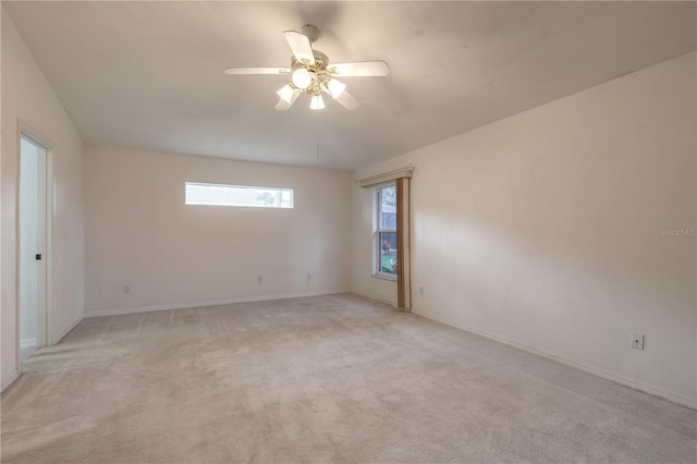 empty room with light carpet, ceiling fan, and baseboards