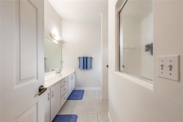 bathroom featuring double vanity, tile patterned flooring, baseboards, and a sink