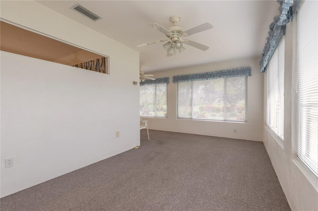 carpeted empty room with visible vents and a ceiling fan